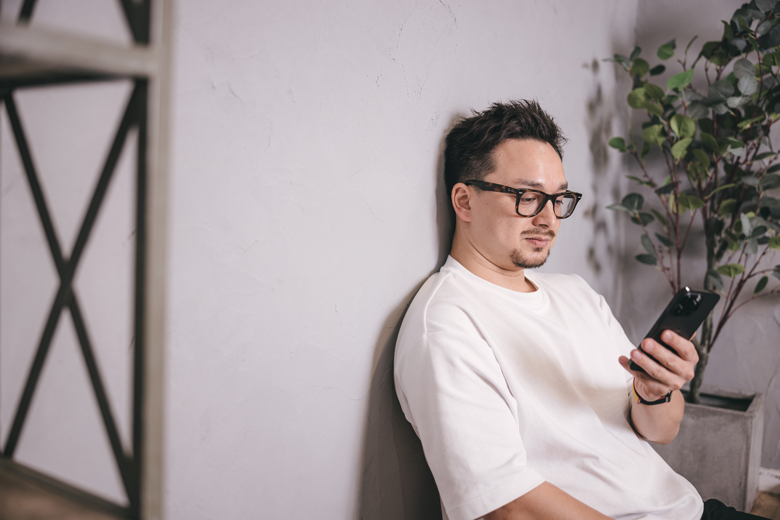 スマホを触るメガネの男性